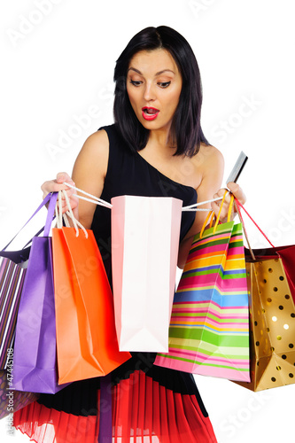 Young brunette with shopping bags isolated on white