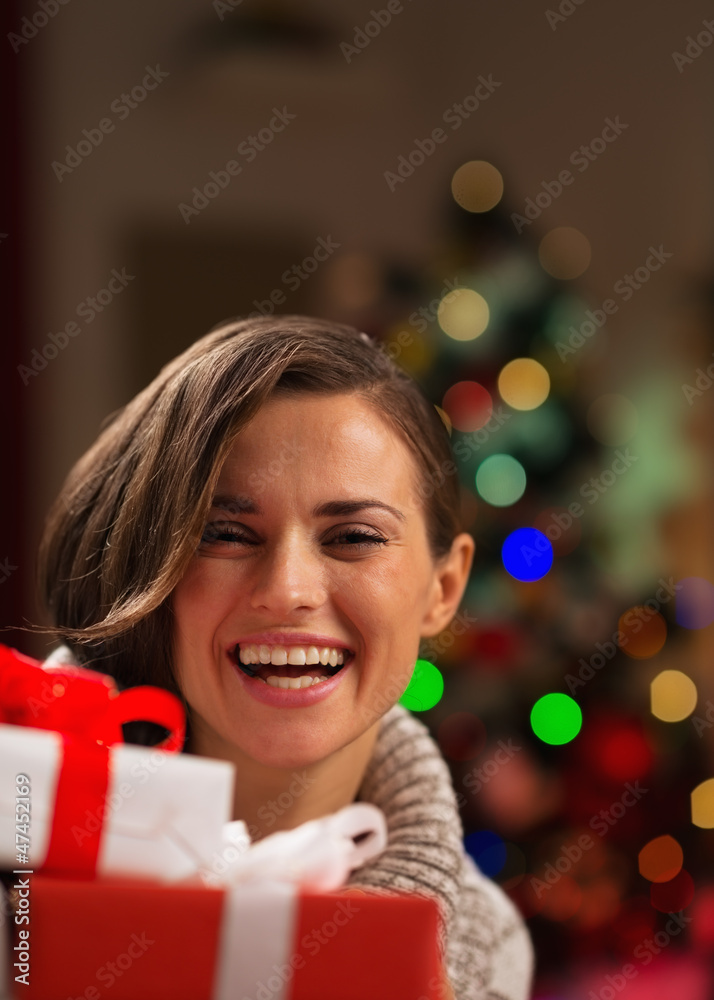 Happy young woman looking out from Christmas gift boxes Happy young woman looking out from Christmas gift boxes