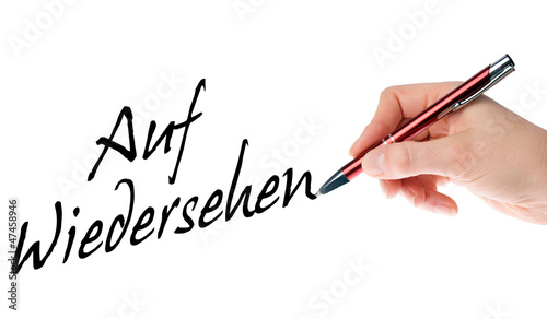 Hand mit Stift schreibt Auf Wiedersehen photo