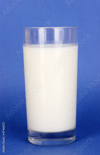 Glass of fresh new milk on blue background