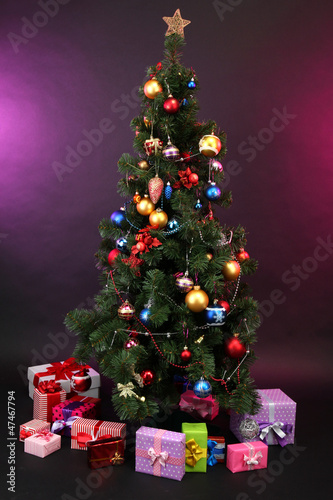 Decorated Christmas tree with gifts on dark color background