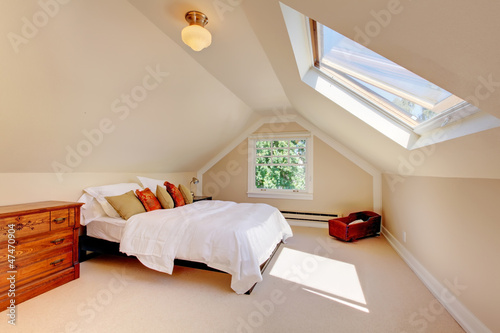 Attic modern bedroom with white bed and skylight. photo