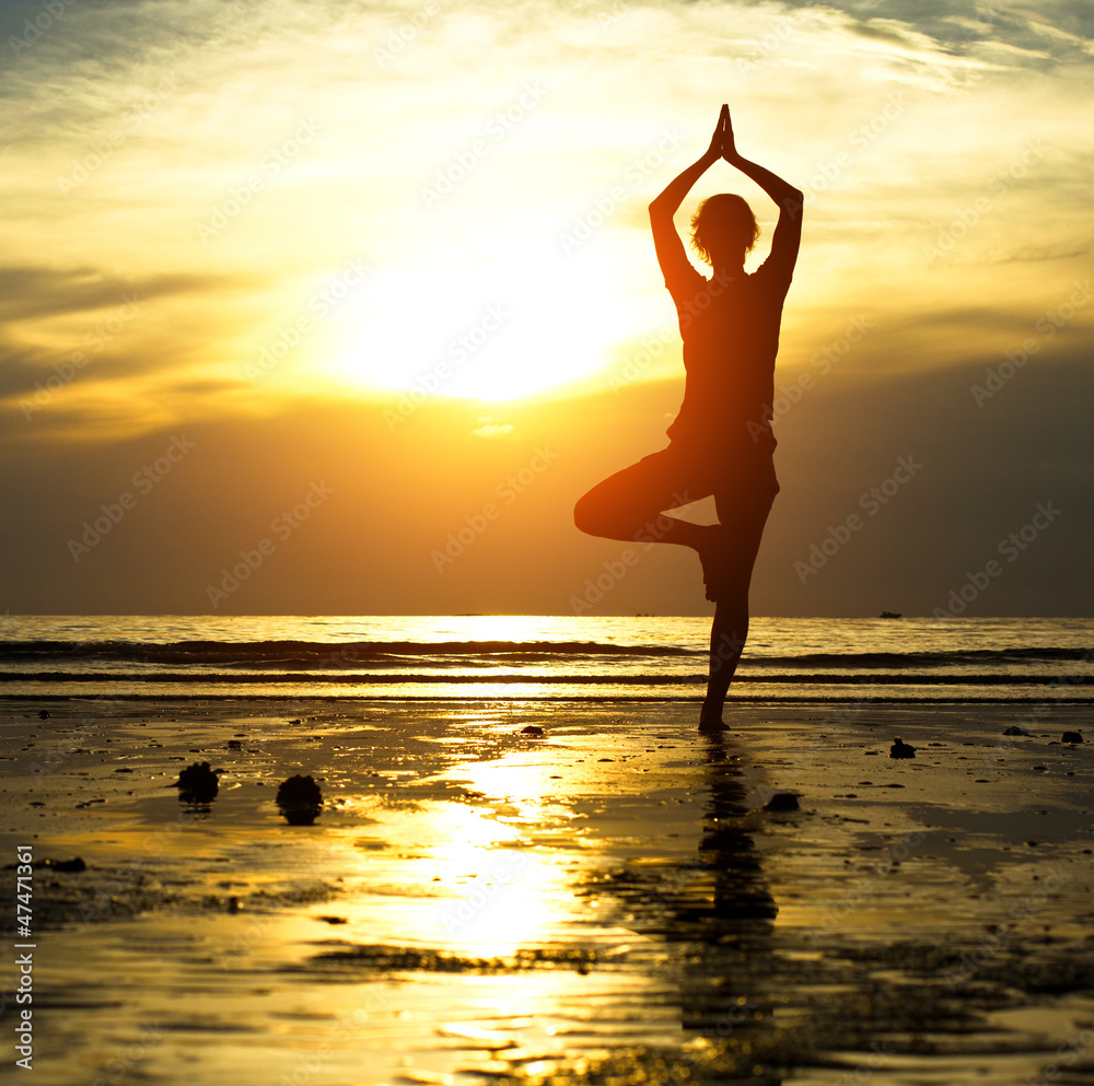 Silhouette of a beautiful yoga woman in the evening - obrazy, fototapety, plakaty 
