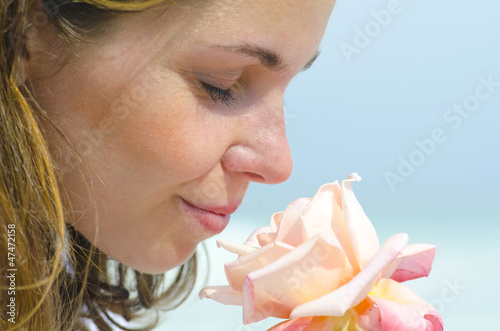 Pretty young girl smelling scent of flower