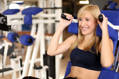Attractive blonde woman weightlifting in a gym