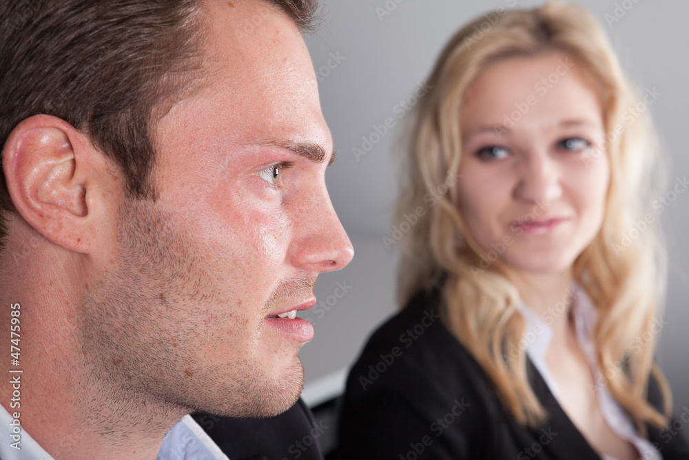 Geschäftsmann sitzt neben Geschäftsfrau Geschäftsmann sitzt neben Geschäftsfrau