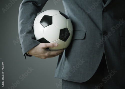 Elegant businessman holding a soccer ball © stokkete