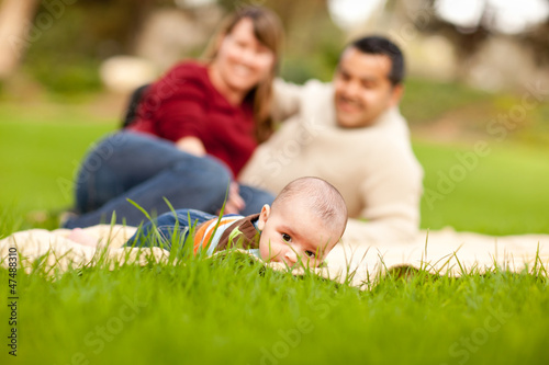 Happy Baby Boy and Mixed Race Parents Playing in the Park