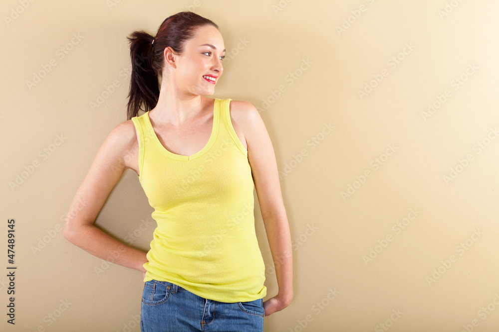 happy young woman standing by the wall happy young woman standing by the wall