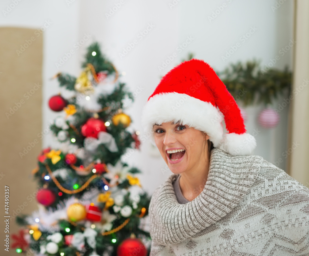 Excited young woman near Christmas tree