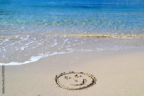 Fotografía Cara sonriente dibujada en la arena de la playa