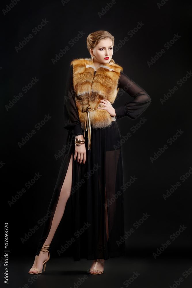 Fototapeta premium Fashion Woman in Luxury Fur Coat over Black Background posing