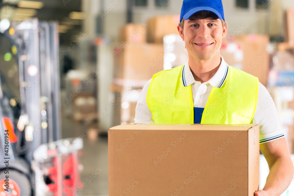 Lagerist von Spedition hält Paket in einem Lager Lagerist von Spedition hält Paket in einem Lager