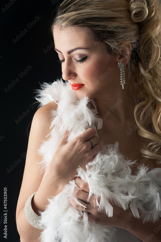 Beautiful blonde woman close up portrait with white ostrich 