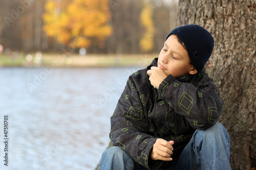 boy relaxing in autumn park