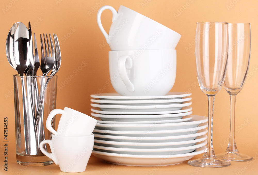 Clean white dishes on beige background Clean white dishes on beige background