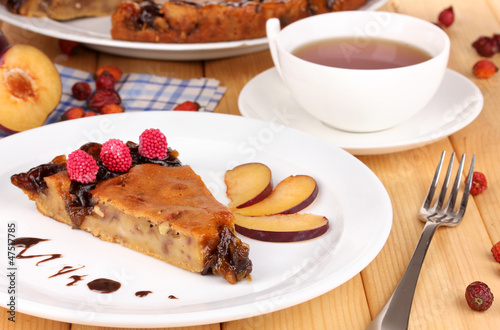 Tasty pie on plate on wooden table