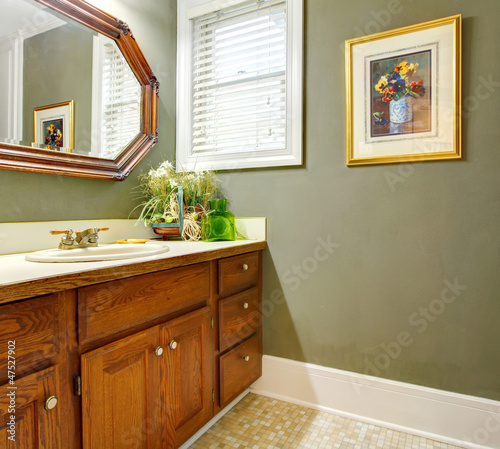 Classic simple green bathroom with wood cabinets.
