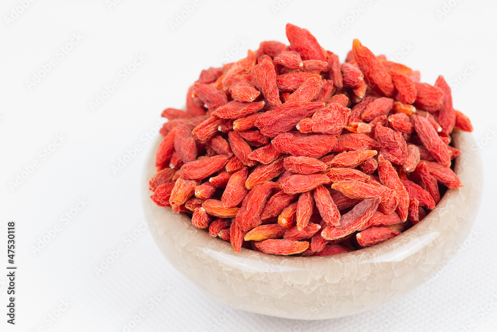 dried wolfberry fruit in bowl on white background