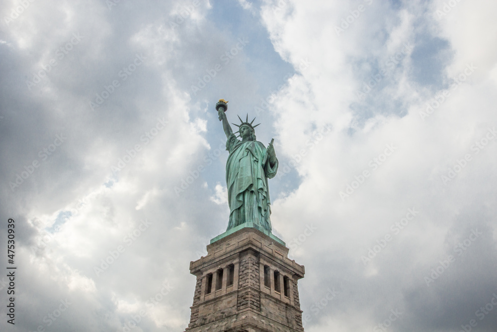 Obraz premium Statue of Liberty against bright sky with clouds