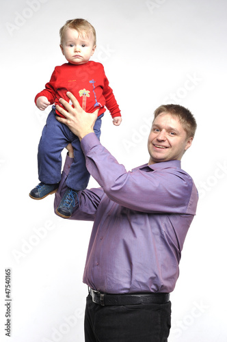 Father in violet shirt holds little boy