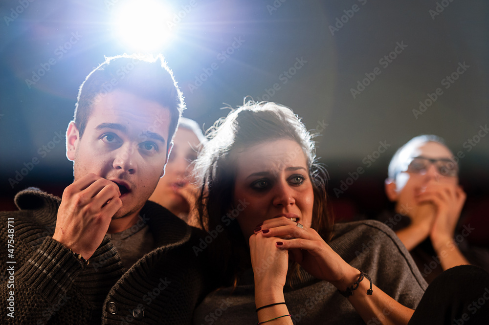 Fototapeta premium Couple scared at the cinema, watching horror movie