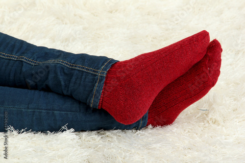 Female legs in colorful socks on  white carpet background