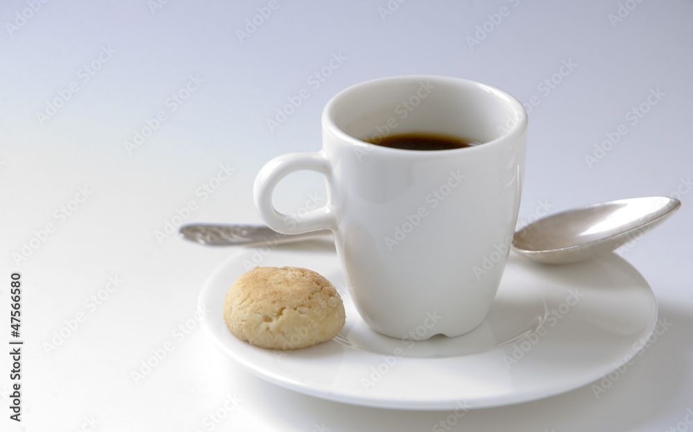 Black espresso coffee cup with steel spoon and small cookie Black espresso coffee cup with steel spoon and small cookie