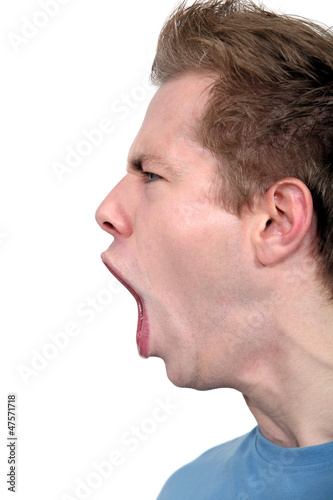 young man in profile shouting angrily