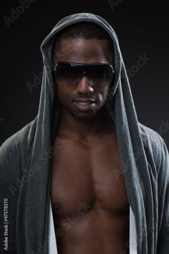 Black fitness man urban style with dark sunglasses. Studio shot.