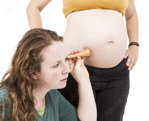 midwife listening at human belly photo