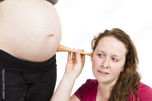 midwife listening at human belly photo