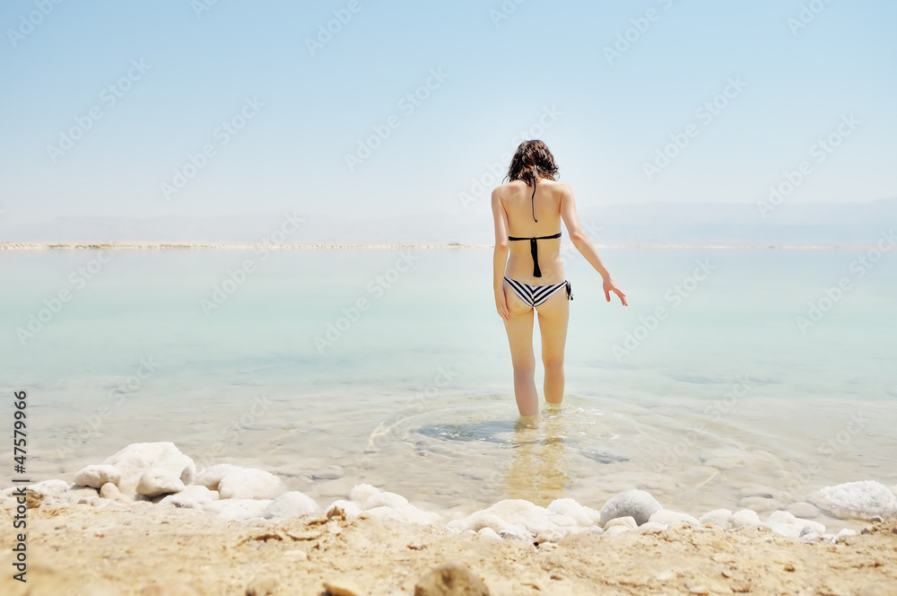 Fototapeta premium Young woman going to water