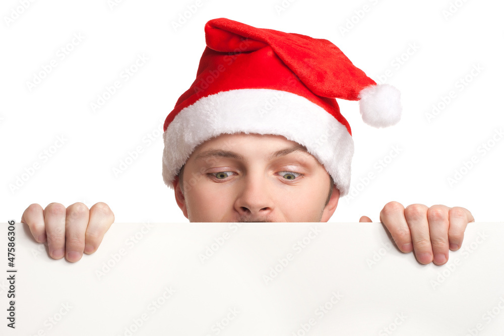 Young man in santa hat holding a blank sign Young man in santa hat holding a blank sign