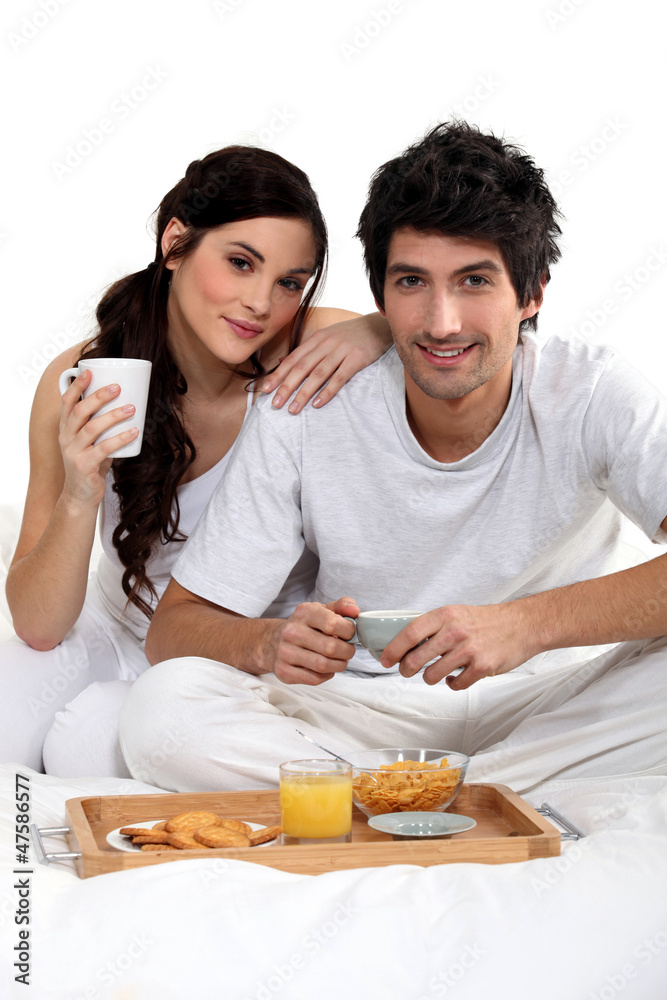 Couple having breakfast in bed Couple having breakfast in bed