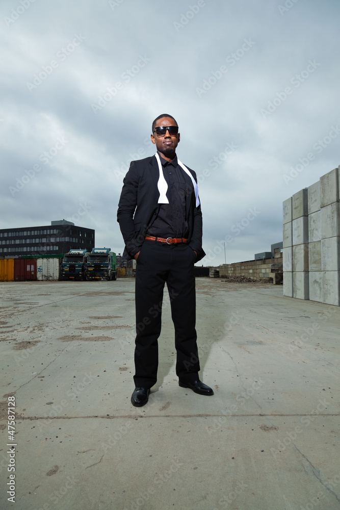 Cool black american man in dark suit wearing sunglasses.