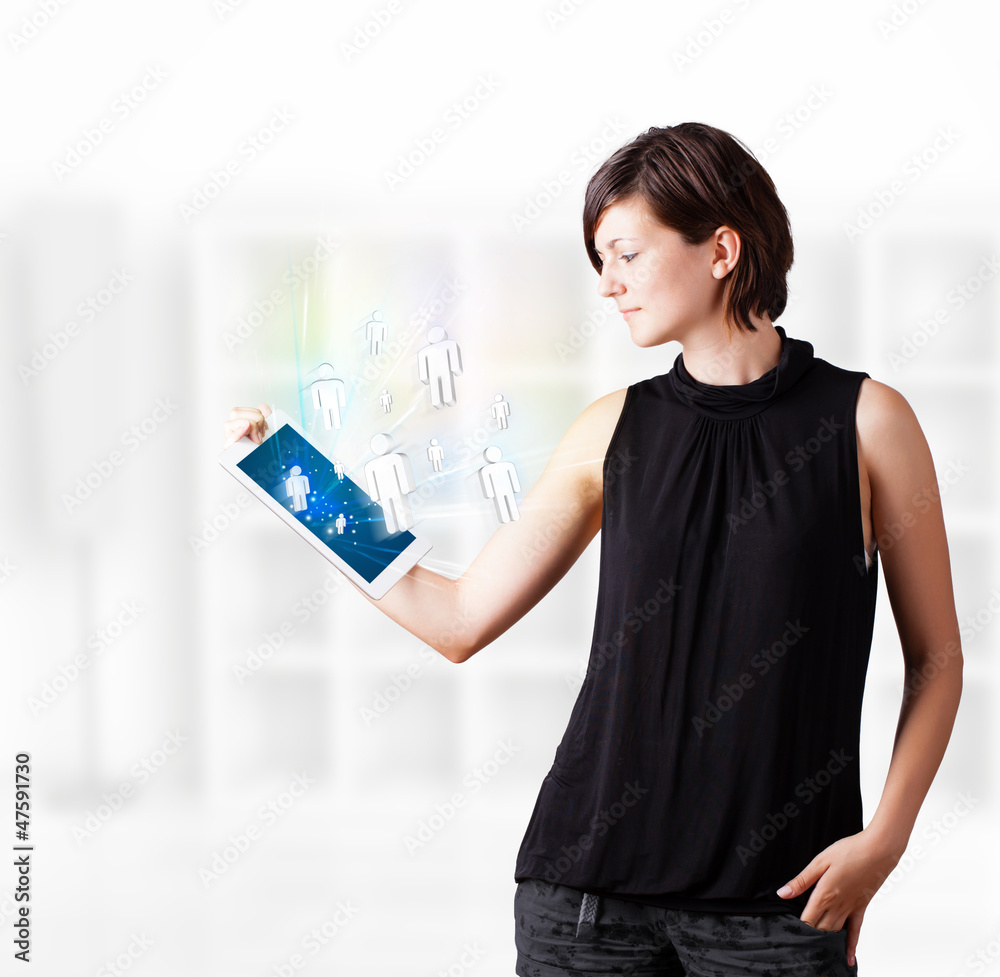 Young woman looking at modern tablet with social icons Young woman looking at modern tablet with social icons