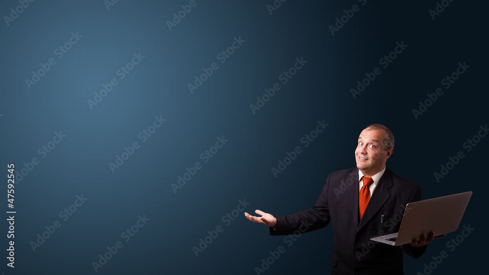 businessman holding a laptop and presenting copy space businessman holding a laptop and presenting copy space