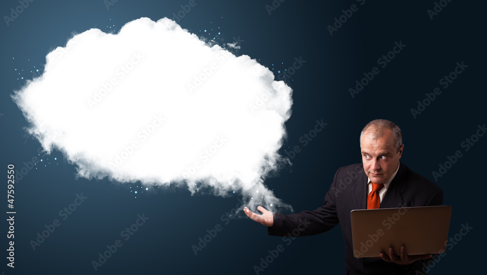 Businessman holding a laptop and presenting abstract cloud copy Businessman holding a laptop and presenting abstract cloud copy