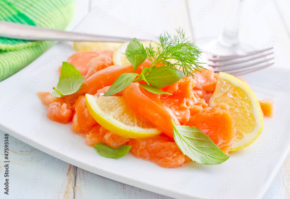 fresh salmon with lemon on the white plate fresh salmon with lemon on the white plate