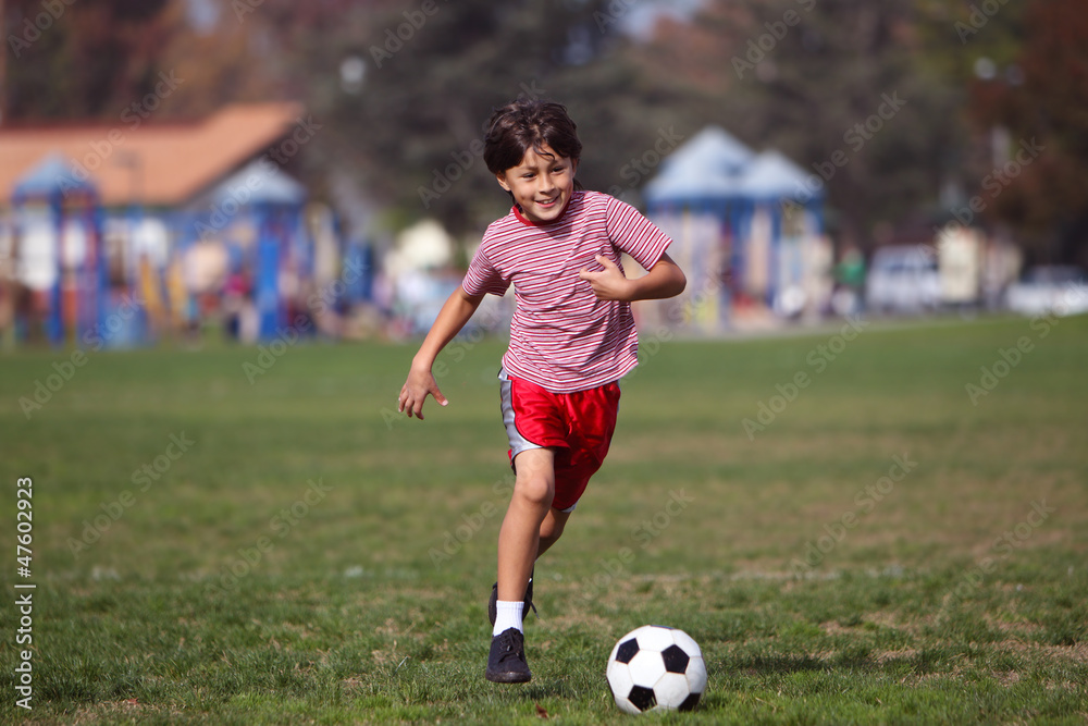 Boy playing soccer in the park