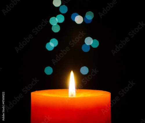 Burning candle on a christmas lights bokeh background