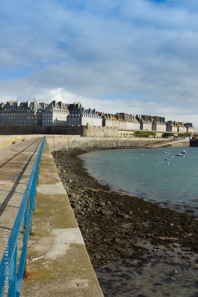 castle walls of Saint Malo old town over sea as viewed from pier