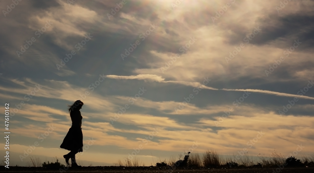 Silhouette of young woman walking