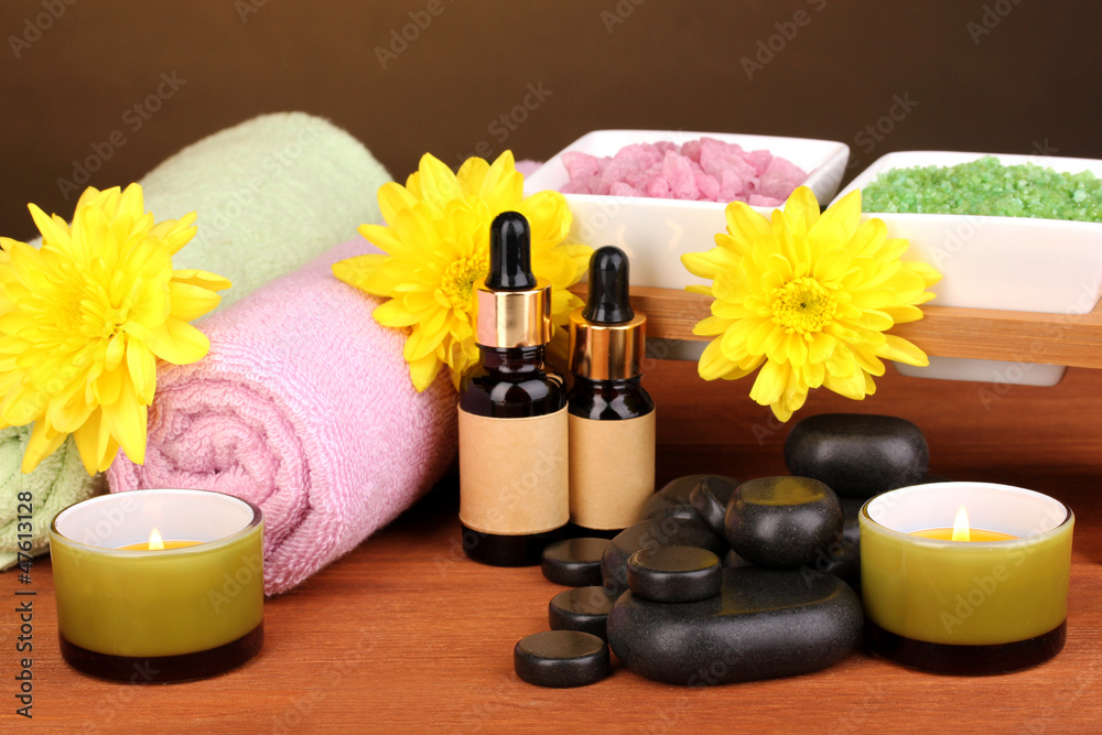 Spa setting on wooden table on brown background