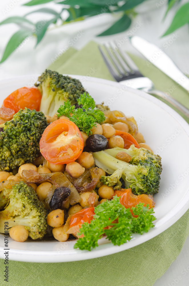 warm salad with chickpeas, broccoli, raisins, closeup warm salad with chickpeas, broccoli, raisins, closeup