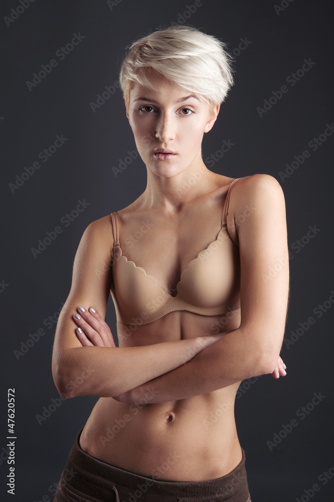 Young woman in lingerie isolated against dark background. Young woman in lingerie isolated against dark background.