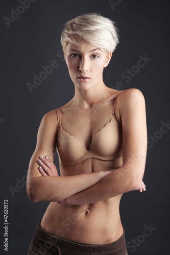 Young woman in lingerie isolated against dark background. 