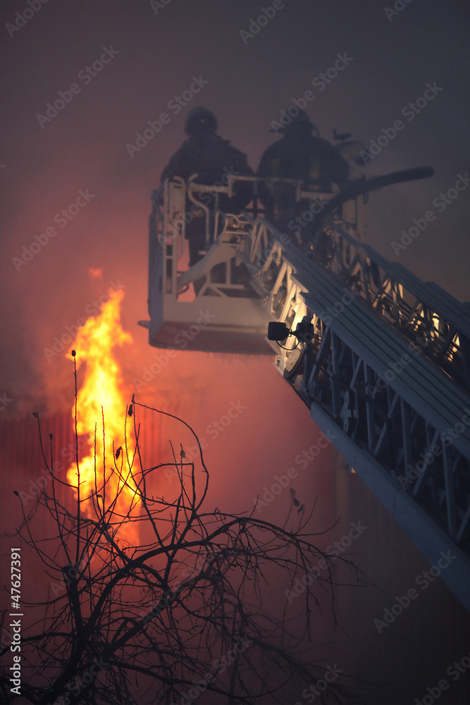 Naklejka premium a huge fire with firefighters in action