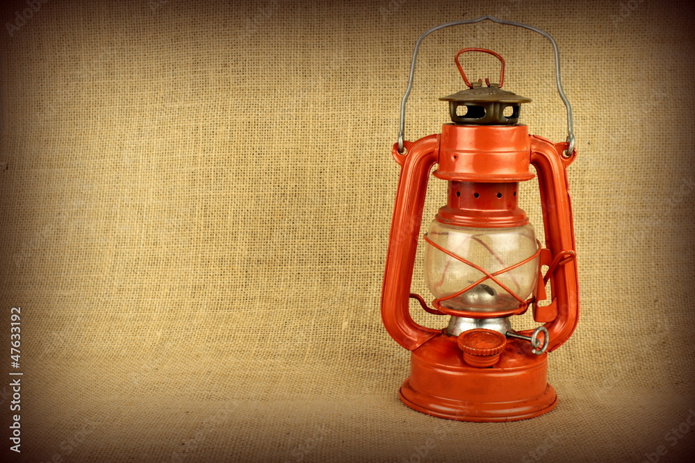 Red oil lamp on burlap and copy space